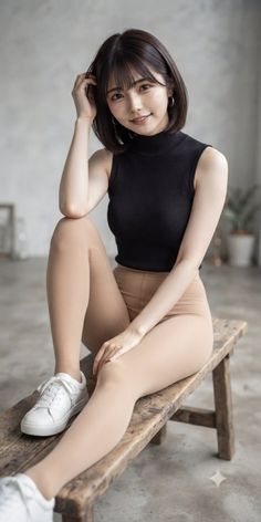 Woman with short hair wearing a black top and tights, sitting on a wooden bench