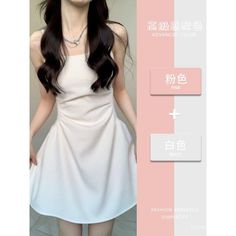 Woman with long dark hair wearing a white dress and necklace indoors