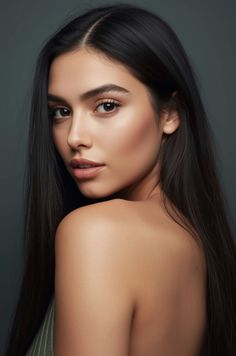 Woman with long black hair and bare shoulders looking over her shoulder