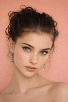 Woman with green eyes and an updo hairstyle wearing earrings