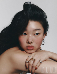 Woman with long black hair and jewelry posing for a portrait