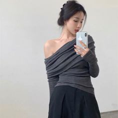 Woman in an off-shoulder top taking a mirror selfie