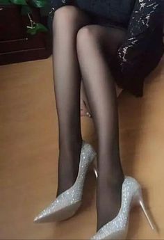 Person wearing black pantyhose and sparkly high heels indoors