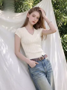 Woman with long hair wearing a v-neck top and jeans outdoors