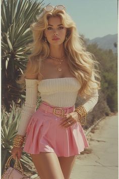 Woman with long blonde hair wearing a pink skirt and off-shoulder top outdoors
