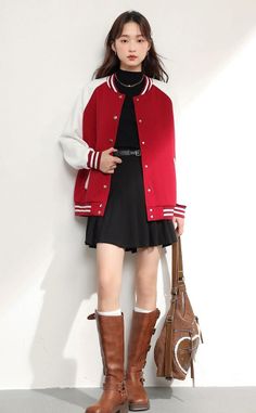 Woman in a red and white varsity jacket, black skirt, and brown boots