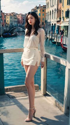 Woman in a white blouse and mini skirt standing by a canal in a European city