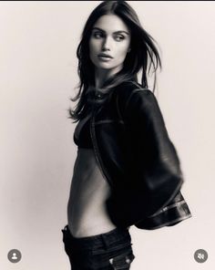 Woman in a leather jacket and bra with exposed midriff in a studio shot
