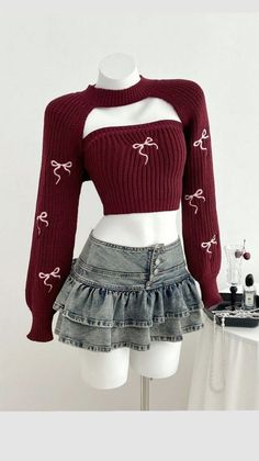 Mannequin wearing a maroon cropped sweater with bows and a ruffled denim skirt