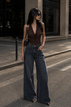 Woman in a brown halter top and wide leg jeans on a city street