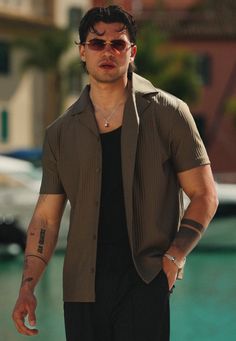 Man in a short sleeve shirt and sunglasses outdoors