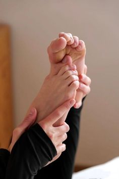 Hands holding and touching feet in a close up shot