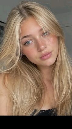 Young woman with long blonde hair and blue eyes looking at the camera