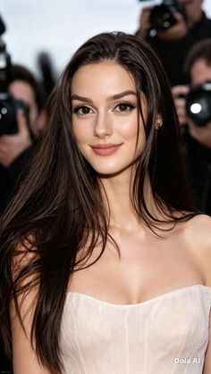Woman with long dark hair wearing a strapless dress, captured in a portrait shot
