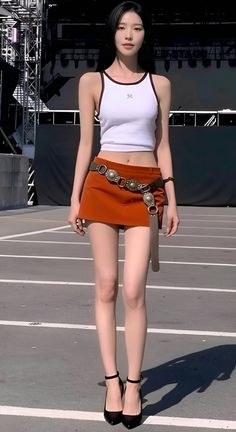 Woman in a white crop top and orange mini skirt with high heels outdoors