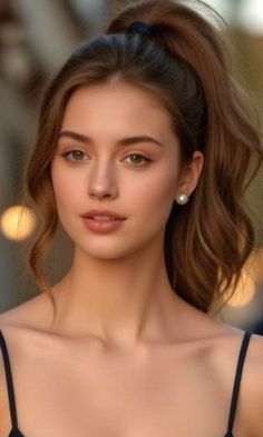 Woman with a ponytail and pearl earrings, wearing a spaghetti strap top