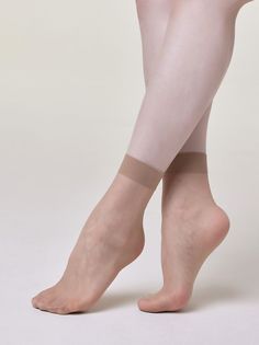 Legs wearing sheer ankle socks, crossed against a light background