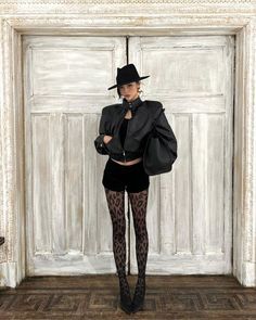 Woman in a black hat and leather jacket with leopard print tights