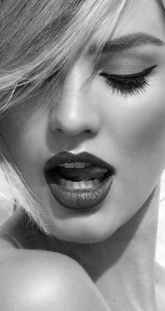 Close up of a woman with blonde hair, closed eyes, and open mouth in black and white