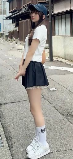 Woman in a baseball cap and mini skirt standing on a street