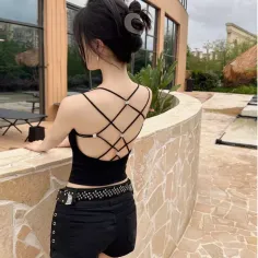 Woman in a black strappy top and shorts with a studded belt, seen from behind