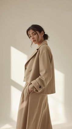 Woman in a tan cropped jacket and matching pants with an updo hairstyle