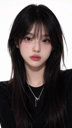 Woman with long black hair and a silver necklace against a white background