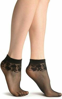Pair of legs wearing black sheer ankle socks with a lace pattern