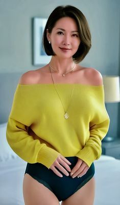 Woman in a yellow off-shoulder top and black underwear posing indoors