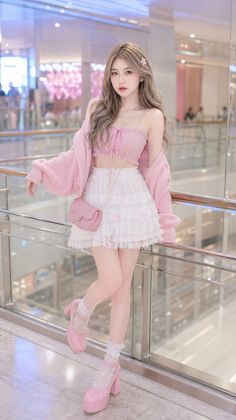 Woman in a pink top and white lace skirt with a pink cardigan and heels indoors