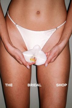 Woman in white underwear holding an orchid flower in a provocative pose