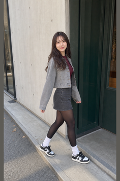 Woman in a denim jacket and skirt walking outdoors