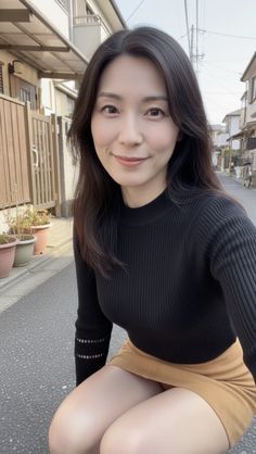 Woman with long dark hair wearing a black sweater and mini skirt outdoors
