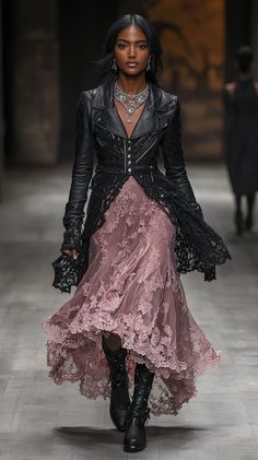 Woman in a black leather jacket and pink lace dress walking on a runway
