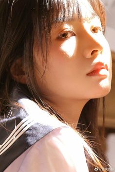 Young woman in a school uniform with dramatic lighting on her face