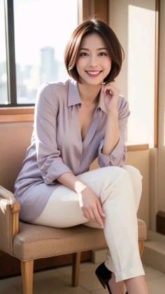 Woman with short hair and a collared shirt sitting indoors