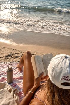 Person reading a book on a beach at golden hour