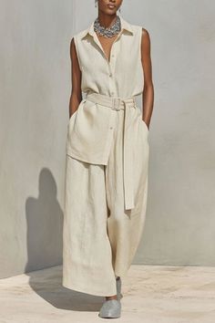 Woman in a sleeveless shirt and wide leg pants with a statement necklace