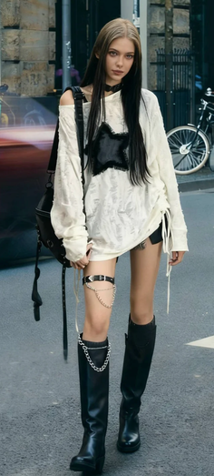 Woman with long hair and a choker wearing a distressed shirt and black boots on a street