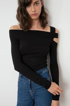 Woman in a black off-shoulder top and blue jeans