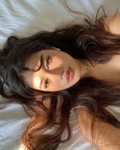 Woman with long hair lying down, illuminated by soft sunlight