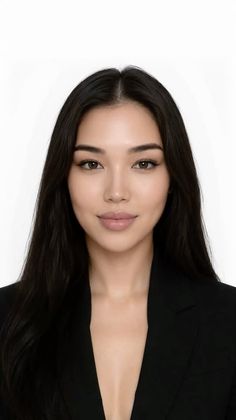 Woman with long black hair wearing a black suit jacket, looking at the camera