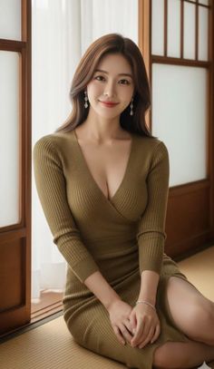 Woman in a ribbed olive green dress with a deep V-neck and slit