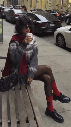 Woman in a sweater and mini skirt sitting on a bench on a city street
