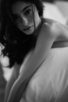 Woman with long hair and freckles in a dramatic black and white portrait