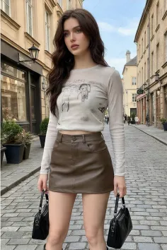 Woman with long brown hair wearing a mini skirt and long sleeve top on a cobblestone street
