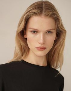 Woman with long blonde hair wearing a black shirt, captured in a portrait
