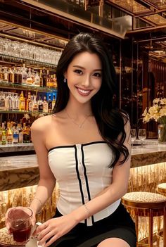 Woman with long dark hair wearing a strapless top in a bar setting