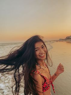 Woman with long hair and a bikini top on a beach at sunset