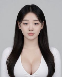 Woman with long black hair wearing a white top with visible cleavage